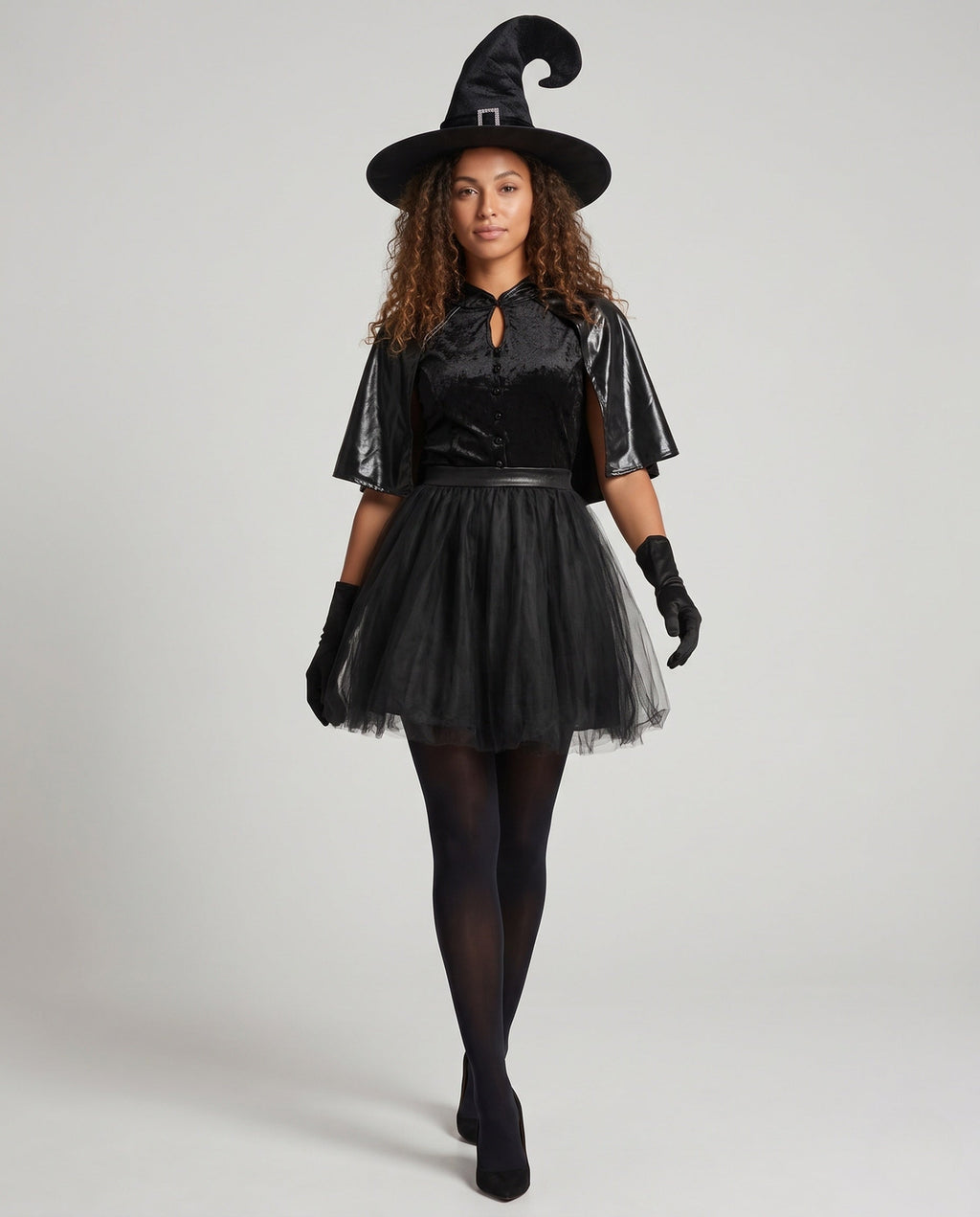 Women's black witch Halloween costume with velvet keyhole bodice, leather-look capelet and tulle skirt