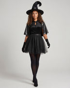 Women's black witch Halloween costume with velvet keyhole bodice, leather-look capelet and tulle skirt