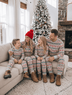 Family wearing matching Fair Isle Christmas pajamas with reindeer print and gray ribbed cuffs - view 2