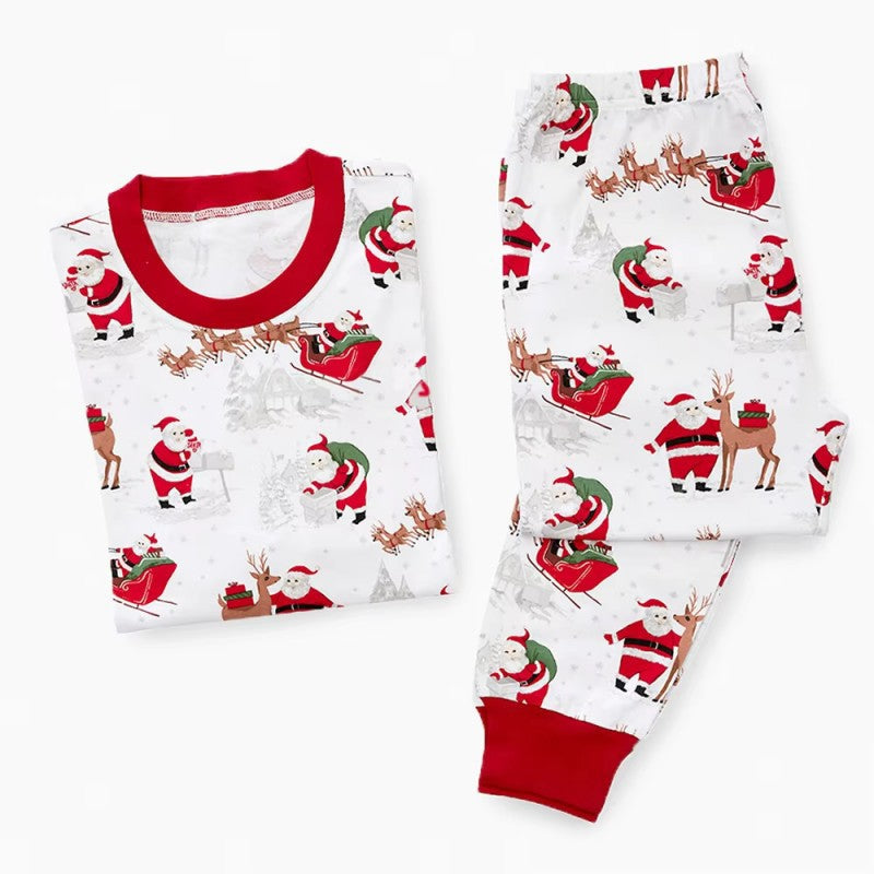 Family wearing matching white Christmas pajamas with Santa sleigh and reindeer print and red trim - view 10