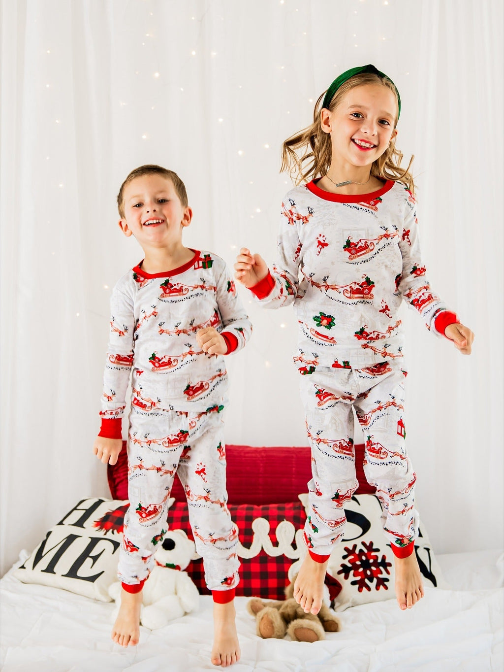 Family wearing matching white Christmas pajamas with Santa sleigh and reindeer print and red trim - view 3