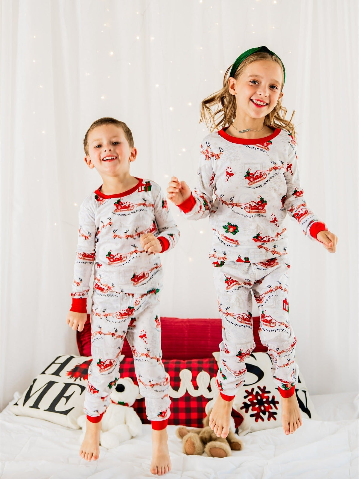 Family wearing matching white Christmas pajamas with Santa sleigh and reindeer print and red trim - view 3