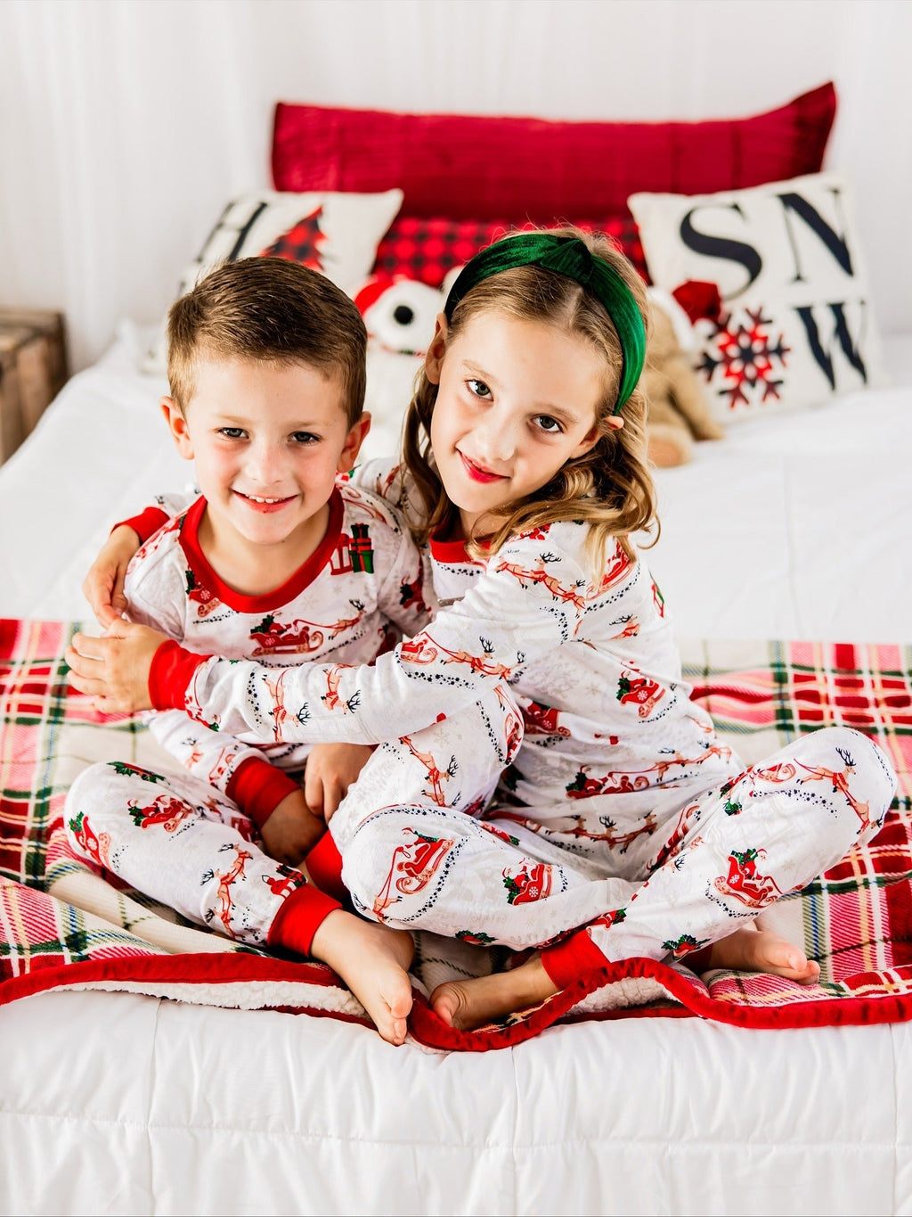 Family wearing matching white Christmas pajamas with Santa sleigh and reindeer print and red trim - view 4