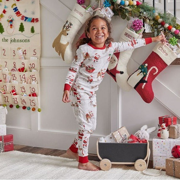 Family wearing matching white Christmas pajamas with Santa sleigh and reindeer print and red trim - view 5