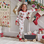 Family wearing matching white Christmas pajamas with Santa sleigh and reindeer print and red trim - view 5