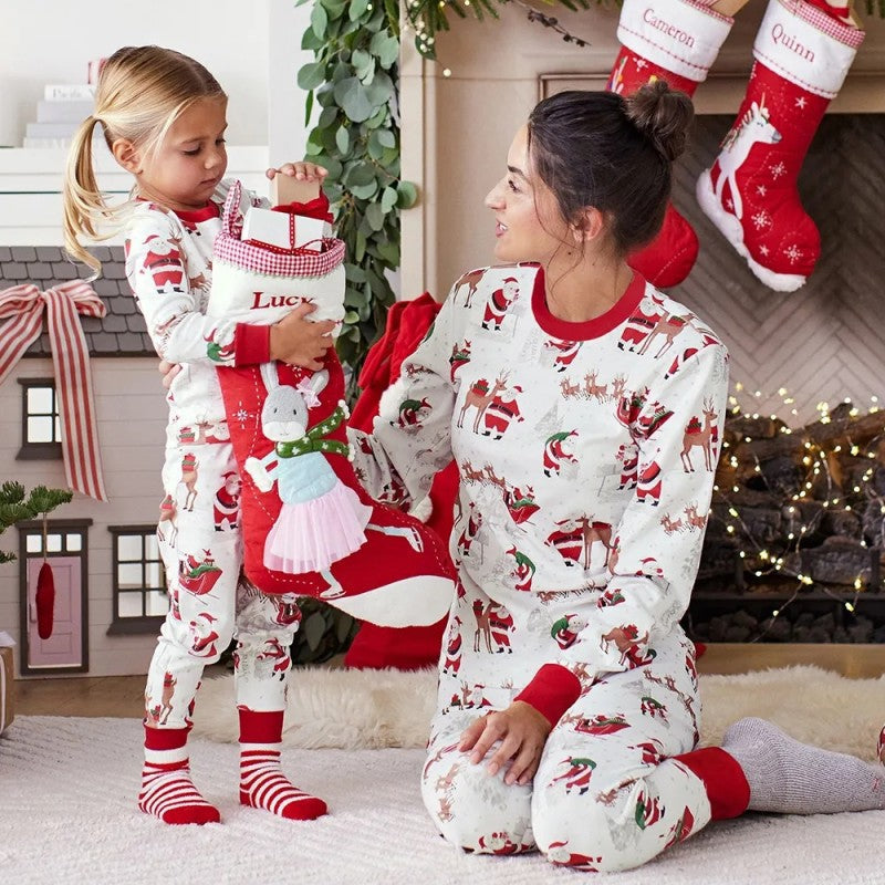 Family wearing matching white Christmas pajamas with Santa sleigh and reindeer print and red trim - view 6