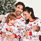 Family wearing matching white Christmas pajamas with Santa sleigh and reindeer print and red trim - view 7