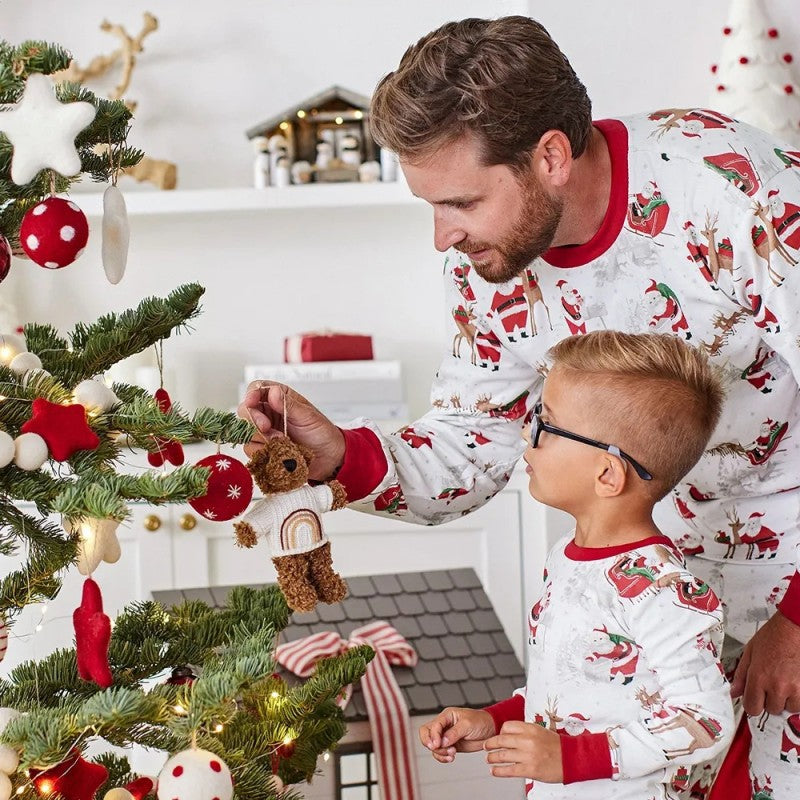 Family wearing matching white Christmas pajamas with Santa sleigh and reindeer print and red trim - view 8