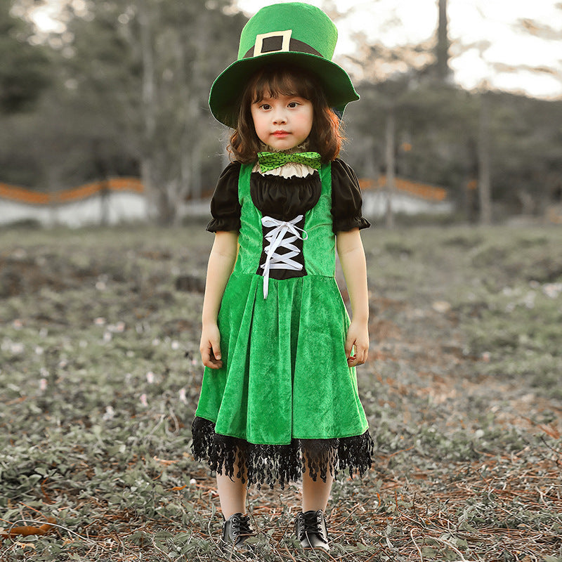 Girl wearing a green velvet leprechaun costume dress with lace-up front, black puff sleeves, fringed hem and tall buckled hat