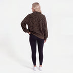 Woman wearing an oversized quarter zip sweatshirt in dark brown leopard print ribbed knit with black leggings - view 2