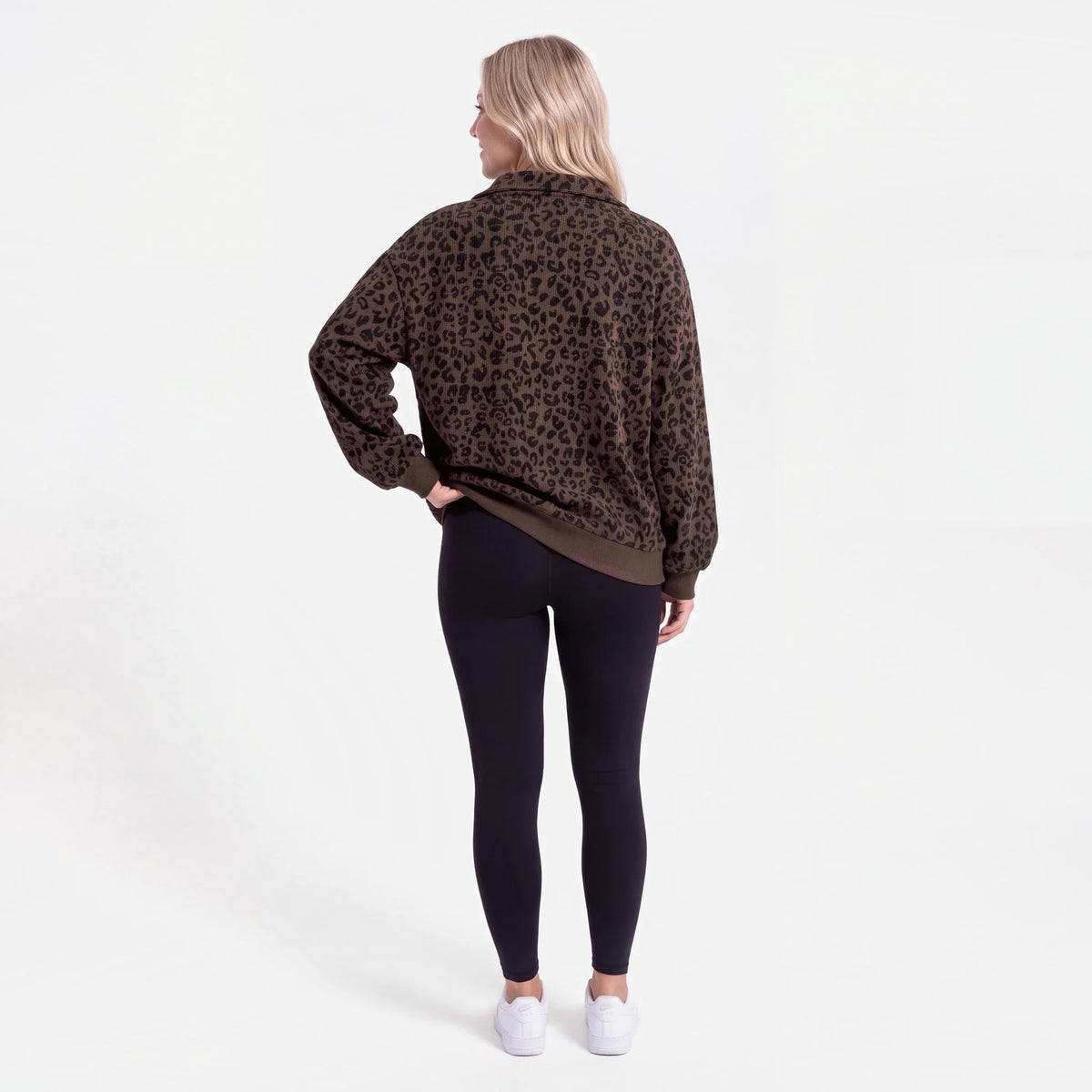 Woman wearing an oversized quarter zip sweatshirt in dark brown leopard print ribbed knit with black leggings - view 2