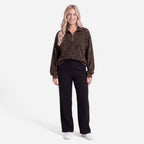 Woman wearing an oversized quarter zip sweatshirt in dark brown leopard print ribbed knit with black leggings - view 3