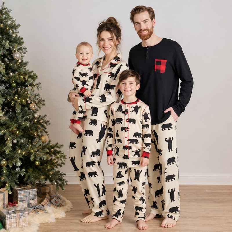 Matching Christmas pajamas with black bear print worn by a family by the tree