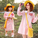 Woman in light pink smock dress Halloween costume with white Peter Pan collar and yellow bucket hat - view 3