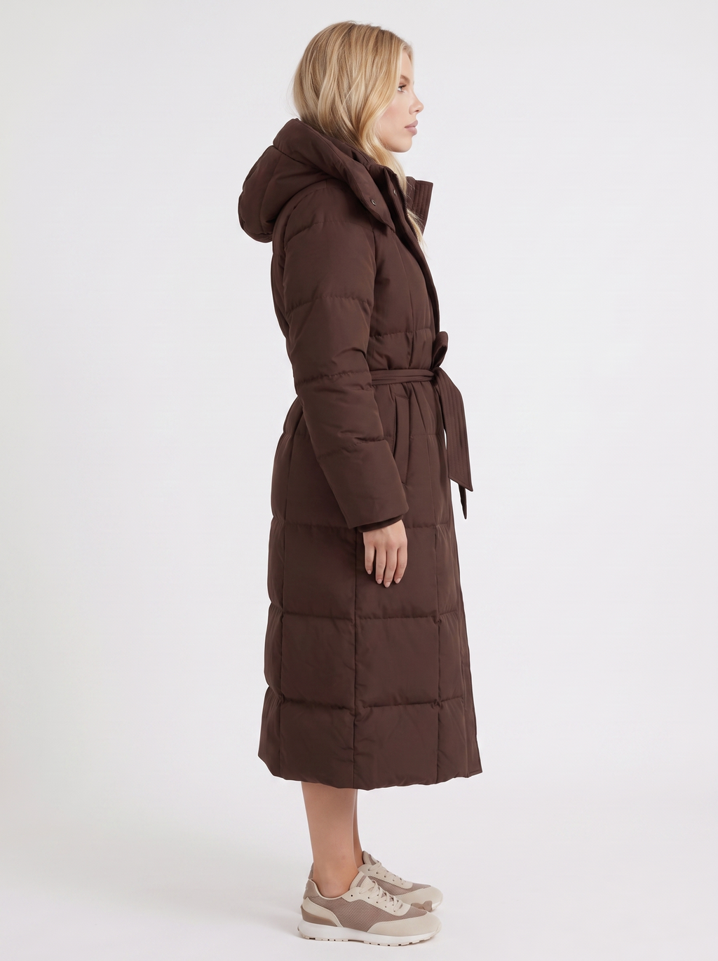 Model in a quilted hooded winter puffer jacket with self-tie belt - view 10