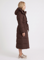 Model in a quilted hooded winter puffer jacket with self-tie belt - view 10