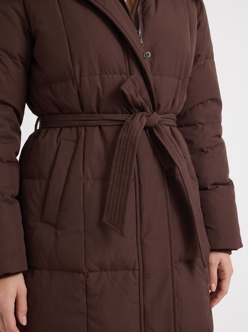 Model in a quilted hooded winter puffer jacket with self-tie belt - view 12