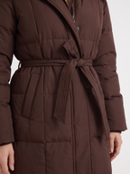 Model in a quilted hooded winter puffer jacket with self-tie belt - view 12