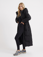 Model in a quilted hooded winter puffer jacket with self-tie belt - view 3