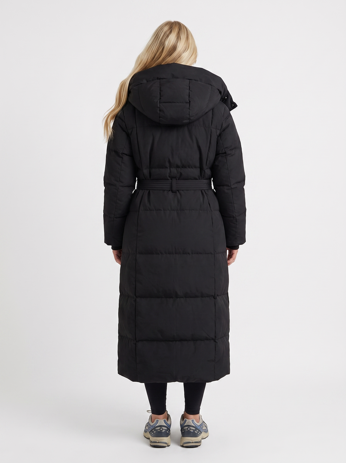 Model in a quilted hooded winter puffer jacket with self-tie belt - view 5