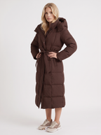 Model in a quilted hooded winter puffer jacket with self-tie belt - view 9