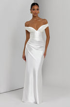 Woman wearing a satin off-shoulder maxi dress with pleated bust and corset bodice