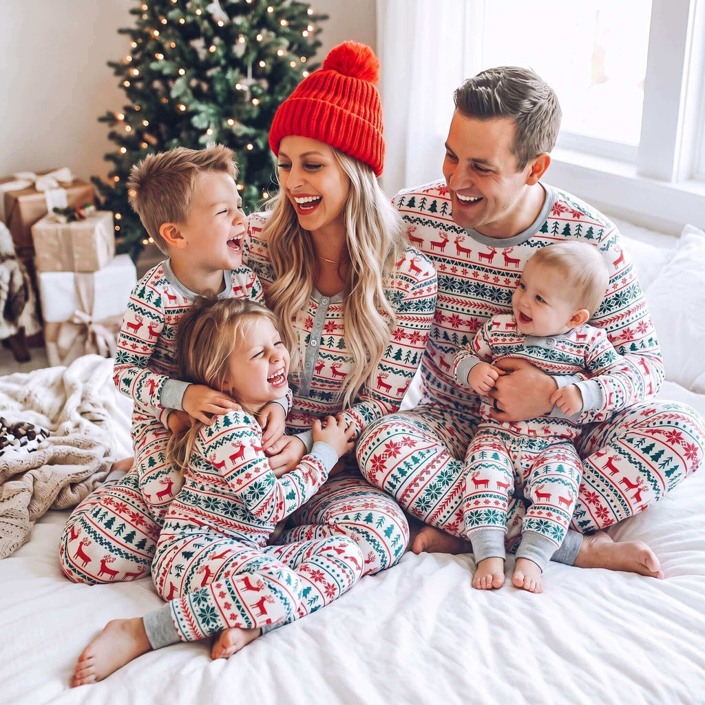 Matching family Christmas pajamas with red and green reindeer and snowflake print and gray ribbed cuffs