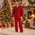 Family wearing matching red plaid Christmas pajamas by the tree - view 2