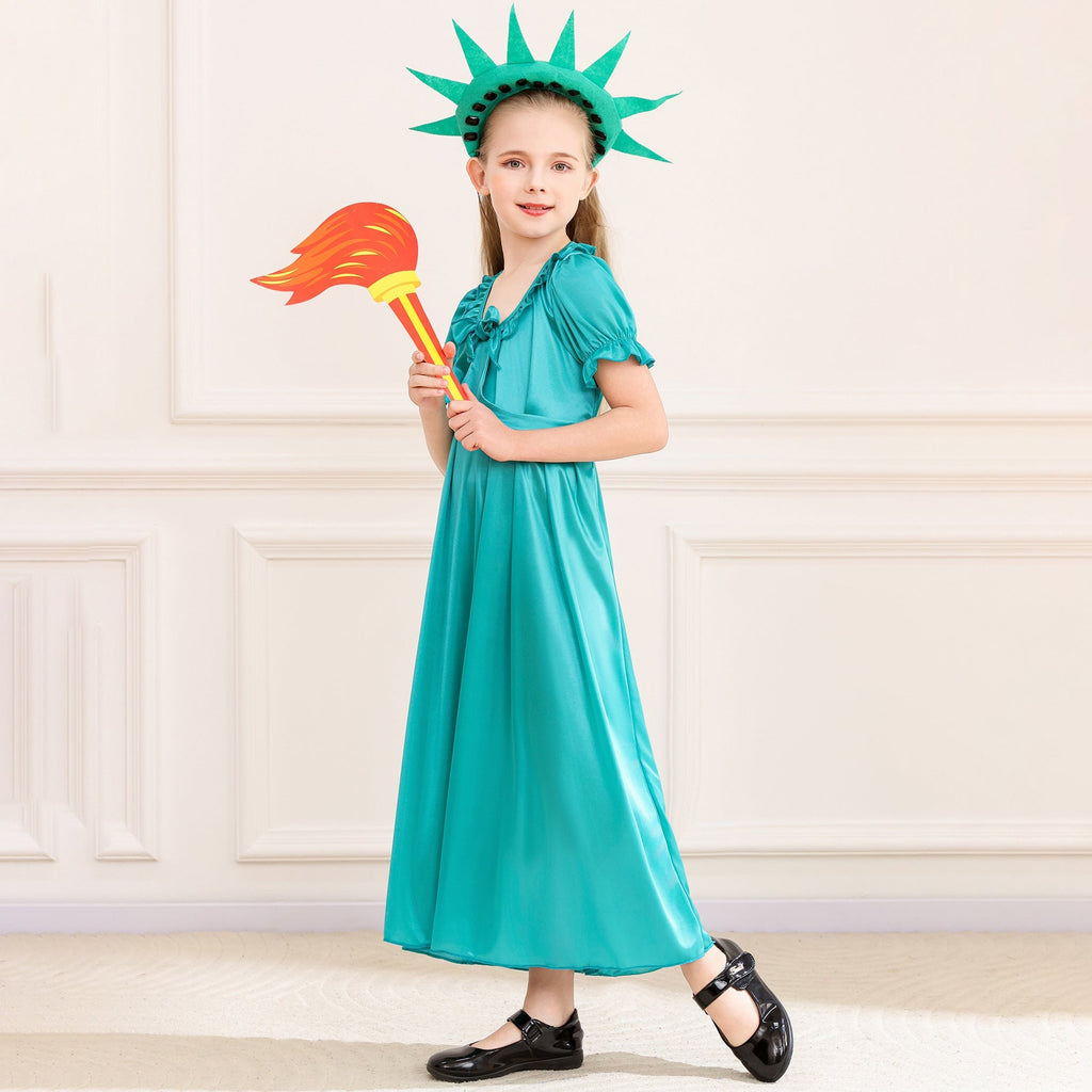 Girl wearing a teal satin-look Statue of Liberty costume dress with spiked crown headband and flame torch prop - view 3
