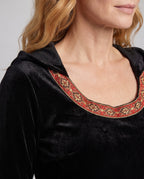 Woman wearing a black velvet hooded costume dress with bell sleeves and red and gold trim - view 3