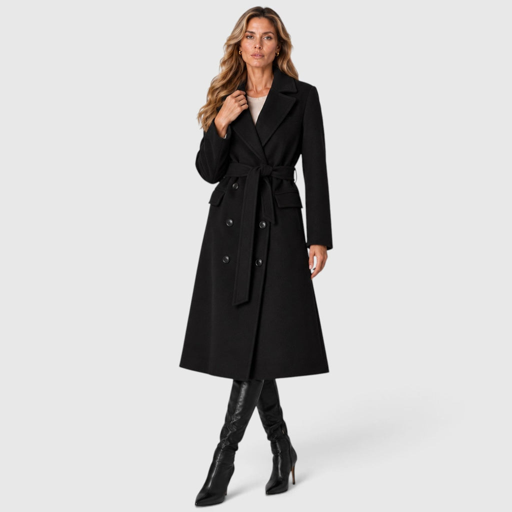 Woman wearing a long double breasted belted coat with wide lapels and knee-high boots