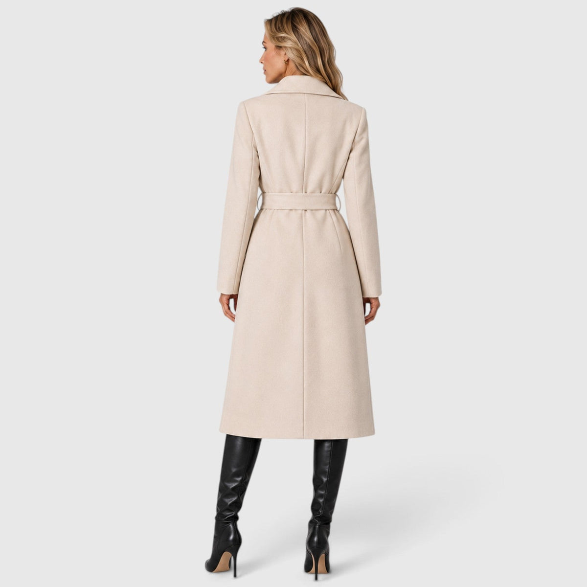 Woman wearing a long double breasted belted coat with wide lapels and knee-high boots - view 16