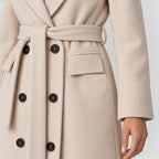 Woman wearing a long double breasted belted coat with wide lapels and knee-high boots - view 17