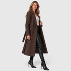 Woman wearing a long double breasted belted coat with wide lapels and knee-high boots - view 5