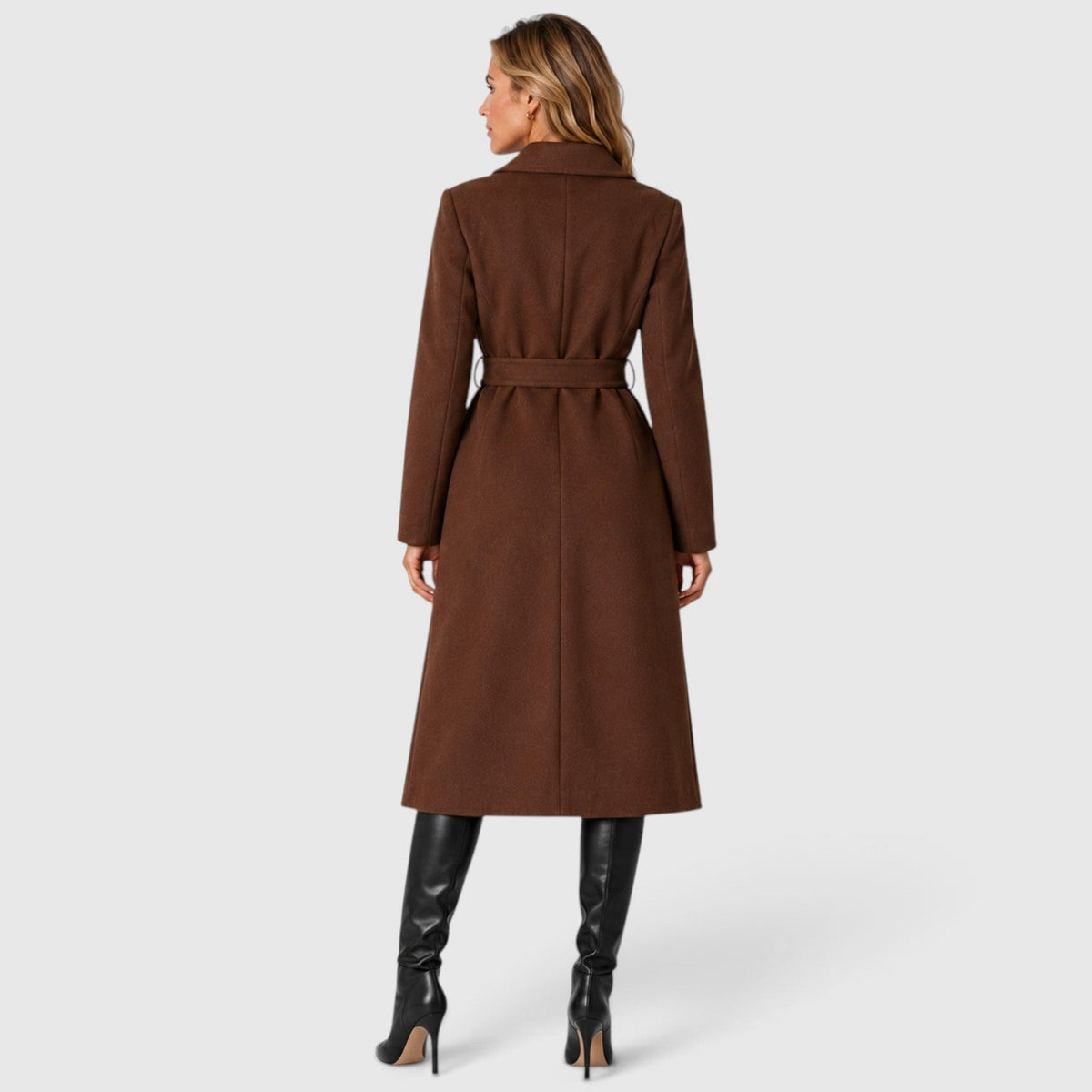 Woman wearing a long double breasted belted coat with wide lapels and knee-high boots - view 9