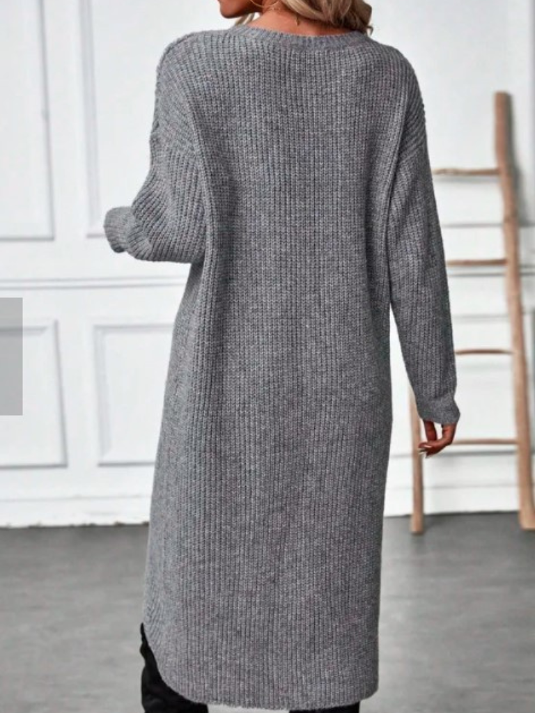 Woman wearing a gray ribbed wrap front long sleeve sweater dress with split high-low hem over black leggings - view 3