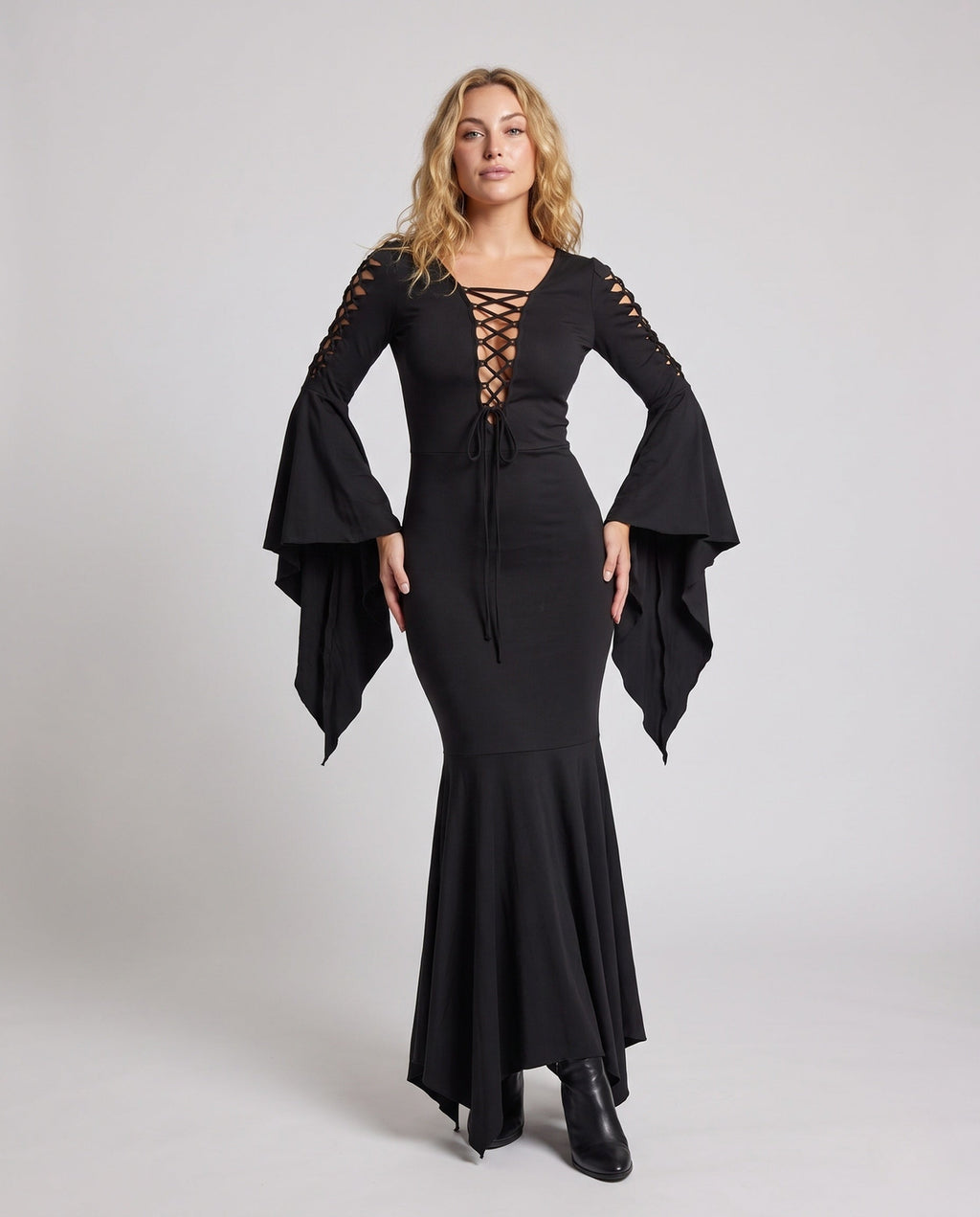 Woman wearing a black lace-up V-neck maxi dress with bell sleeves and mermaid handkerchief hem