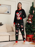 Matching family Christmas pajamas, black top with dabbing Santa graphic and Christmas print jogger pants with red cuffs - view 3