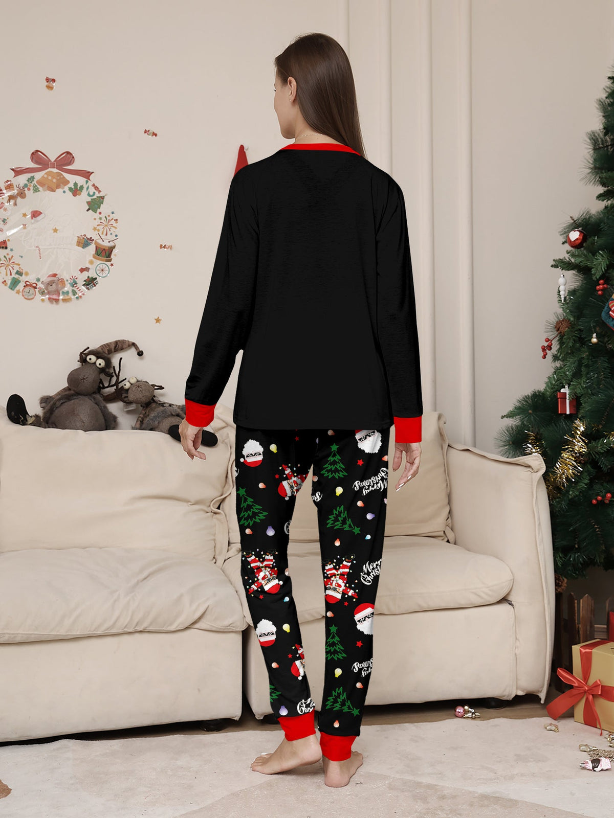 Matching family Christmas pajamas, black top with dabbing Santa graphic and Christmas print jogger pants with red cuffs - view 4