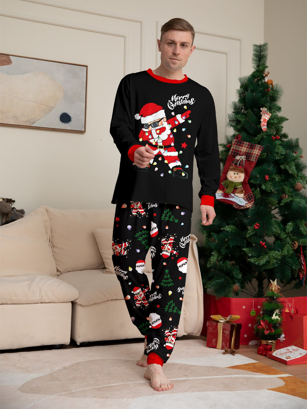 Matching family Christmas pajamas, black top with dabbing Santa graphic and Christmas print jogger pants with red cuffs - view 5