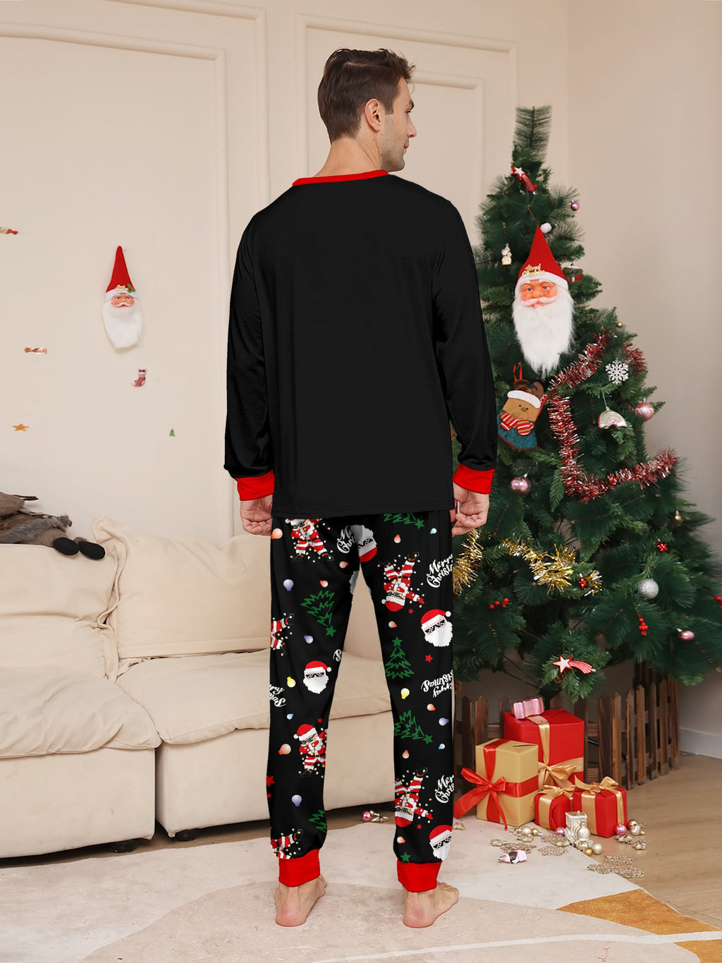 Matching family Christmas pajamas, black top with dabbing Santa graphic and Christmas print jogger pants with red cuffs - view 6