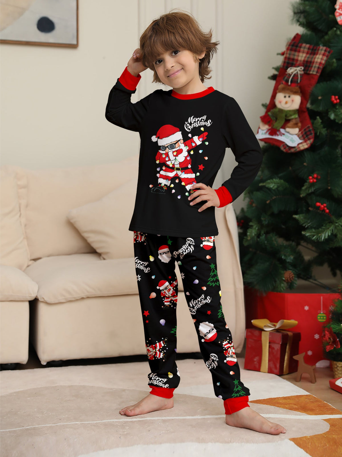 Matching family Christmas pajamas, black top with dabbing Santa graphic and Christmas print jogger pants with red cuffs - view 8