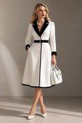 Formal white long sleeve coat dress with black lapels, cuffs and waistband