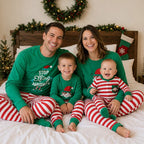 Matching family Christmas pajamas with green elf slogan tops and striped pants