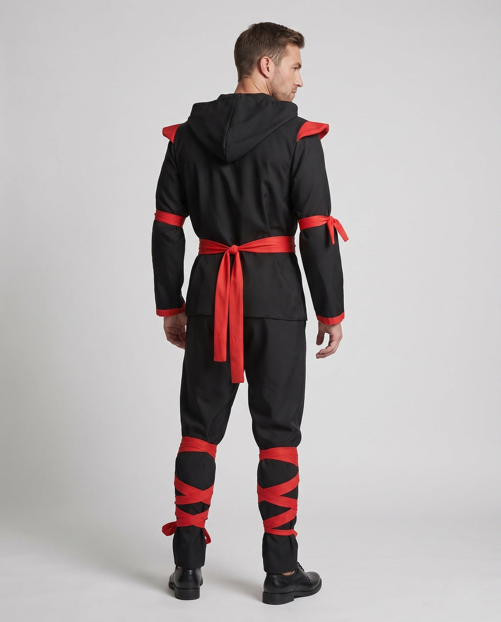 Men's black ninja Halloween costume with hood, red wrap trim, red sash and red leg wraps - view 3