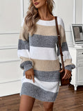 Woman wearing an oversized white, taupe and gray striped sweater dress with balloon sleeves