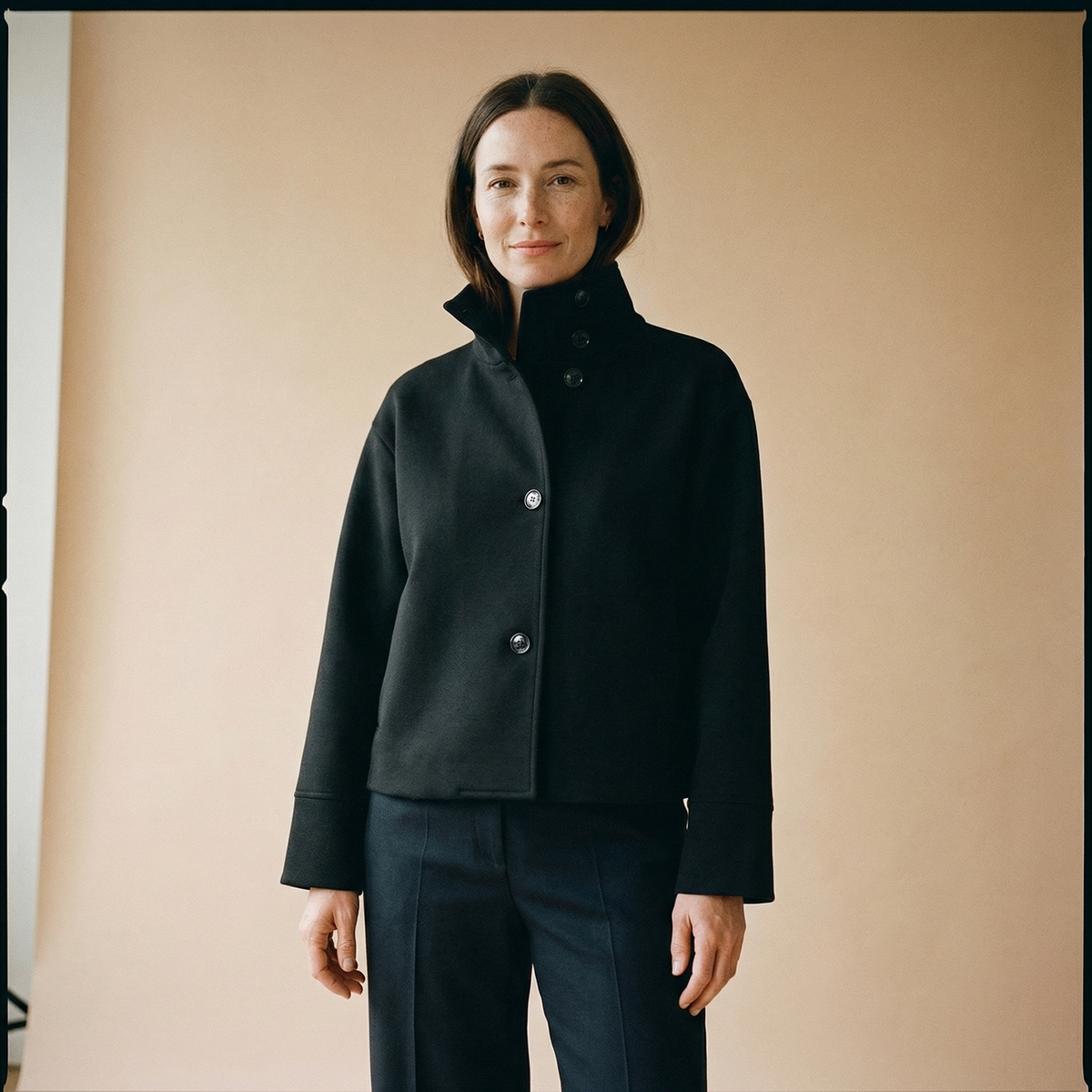 Woman wearing a cropped jacket with a high stand collar and button front, a tailored womens jacket for work - view 4