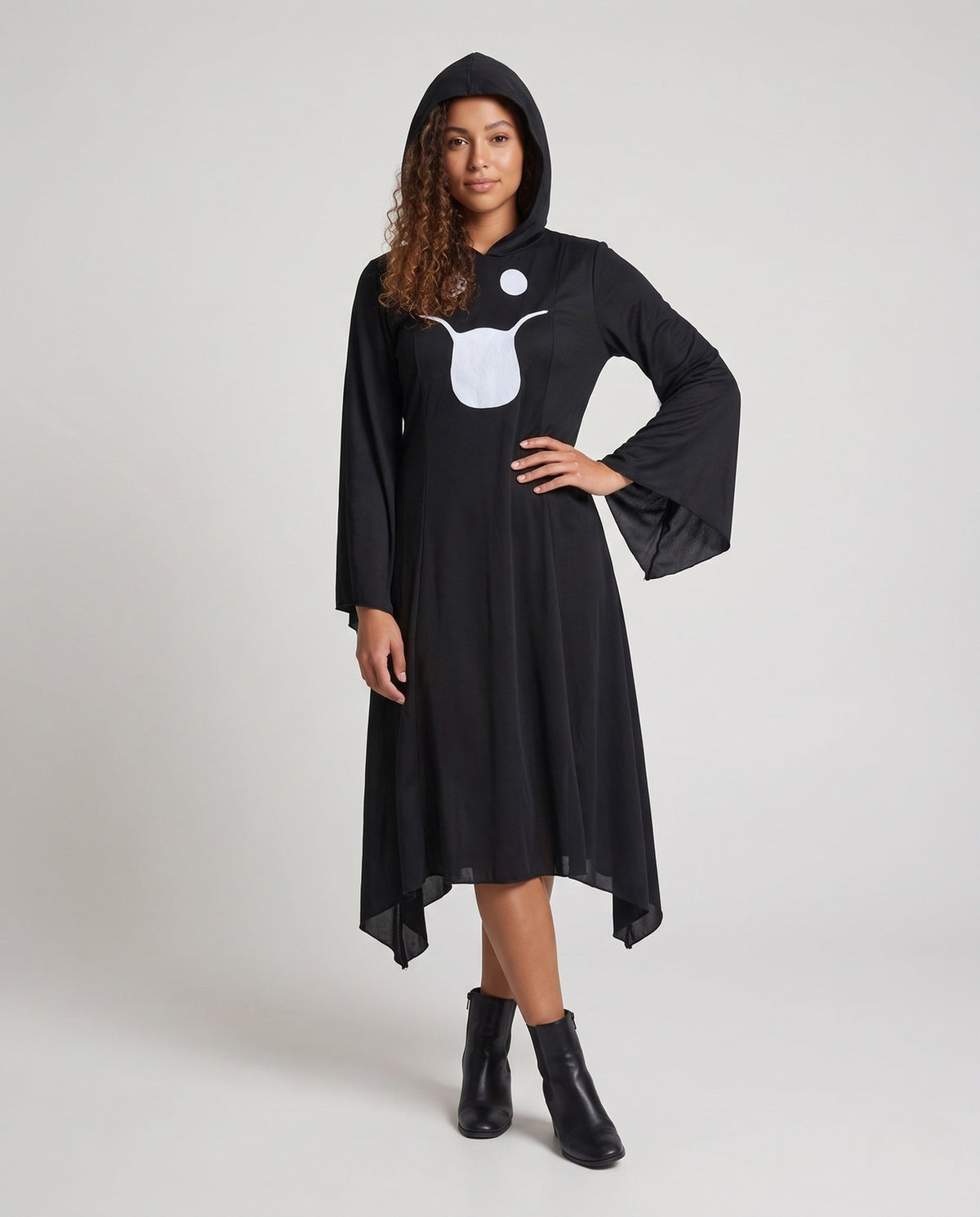 Woman wearing a black hooded Halloween costume dress with a white ghost face, bell sleeves and a handkerchief hem