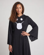 Woman wearing a black hooded Halloween costume dress with a white ghost face, bell sleeves and a handkerchief hem - view 2