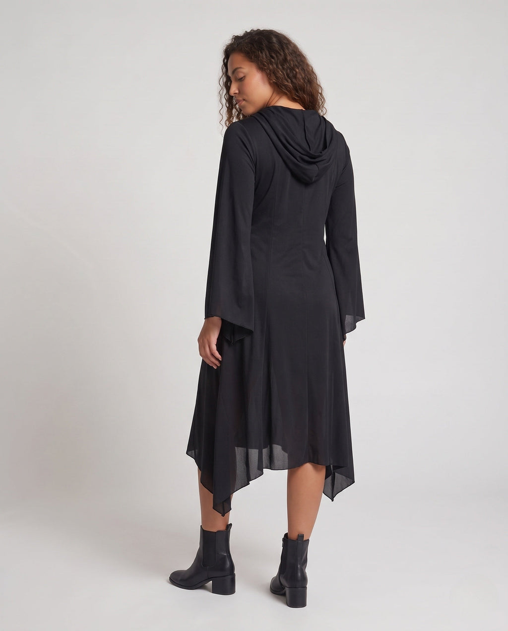 Woman wearing a black hooded Halloween costume dress with a white ghost face, bell sleeves and a handkerchief hem - view 4